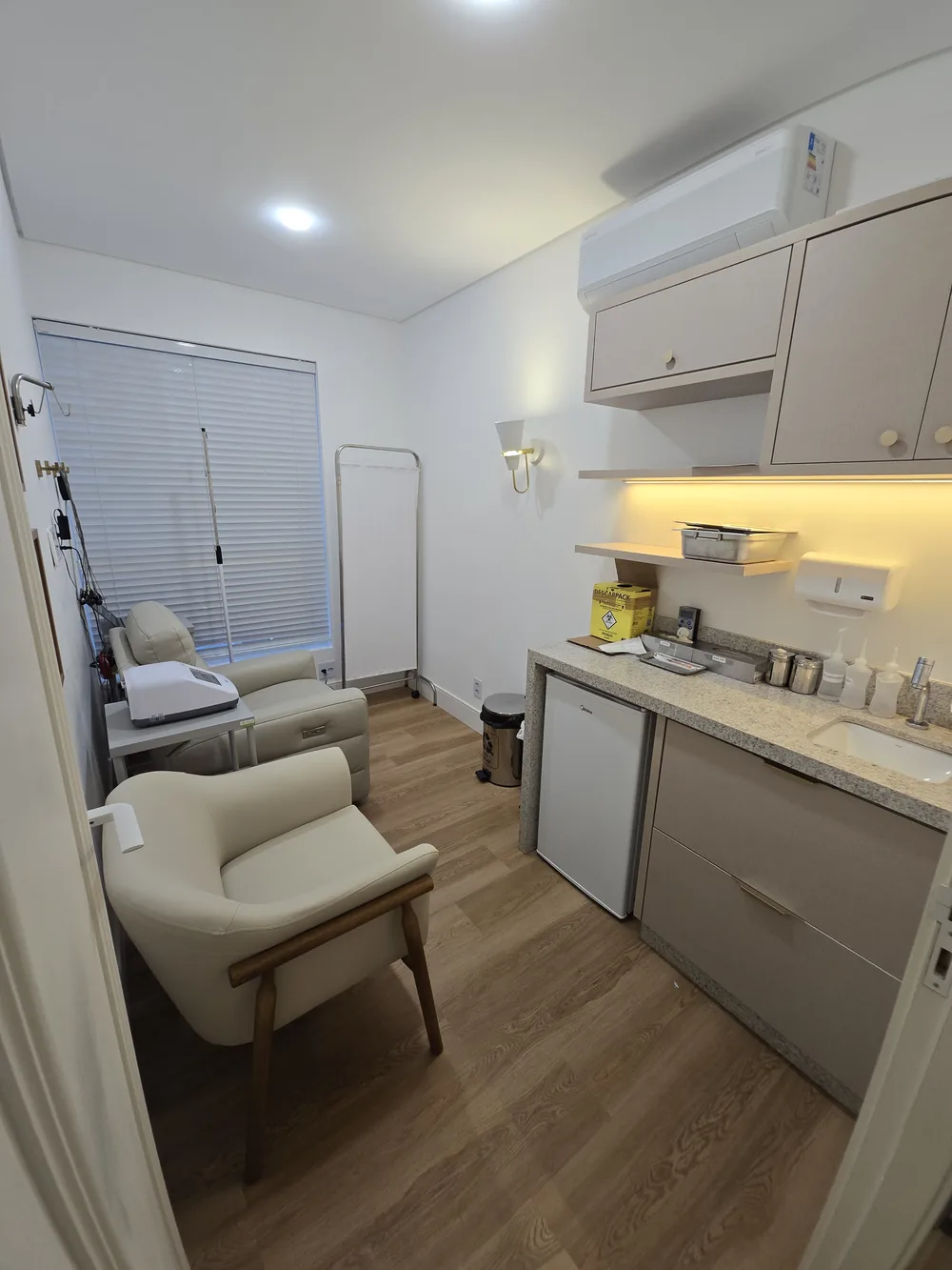 Sala de aplicação de injetáveis, com poltrona confortável e bancada equipada